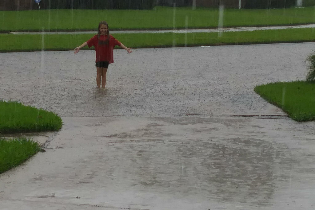 The author's daughter, Brooke, stands in the rain outside her home on Sunday, August 27. Photo credit: Jennifer Davis